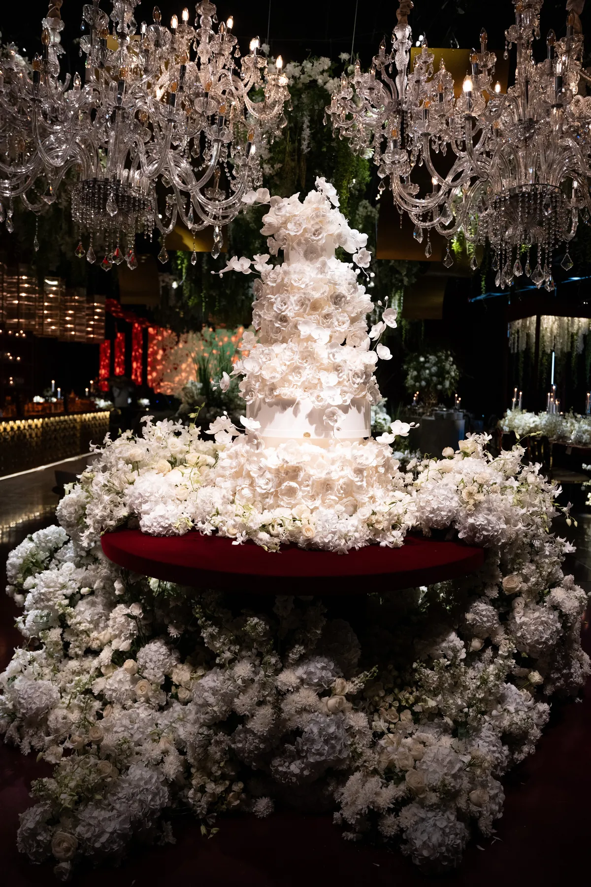 Bolo branco de flores sob lustres de cristal
