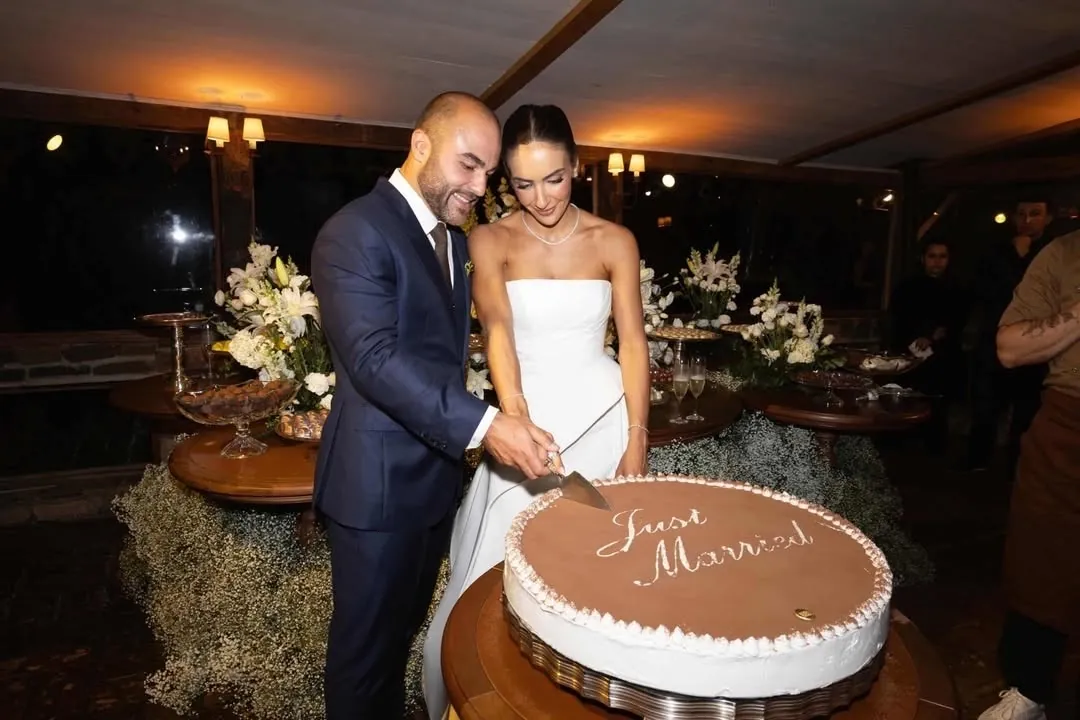 Noivos cortando o bolo escrito Just Married