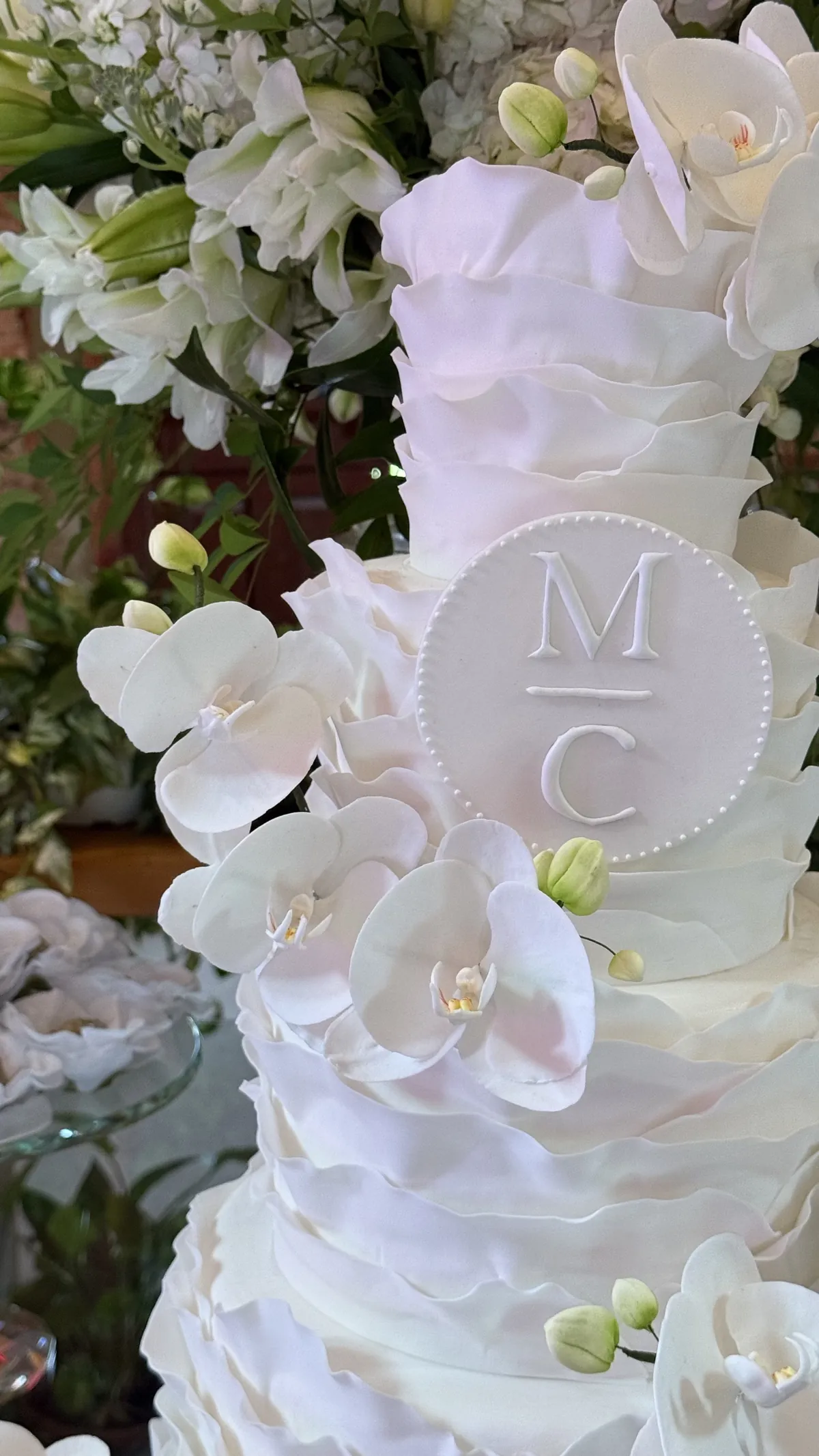 Monograma em relevo entre orquídeas brancas