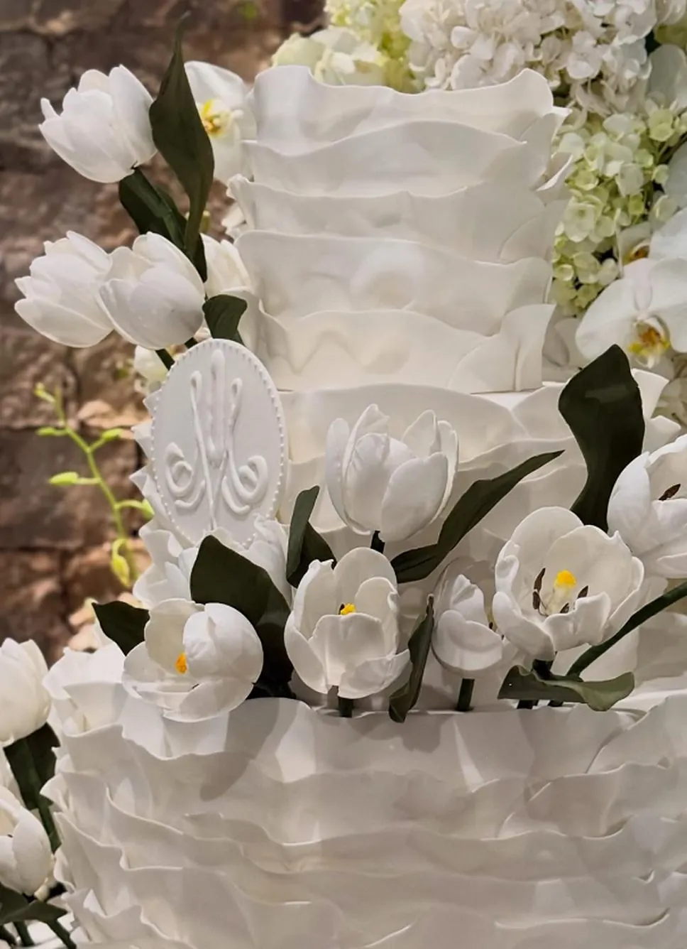 Detalhe de bolo branco com babados e tulipas de açúcar